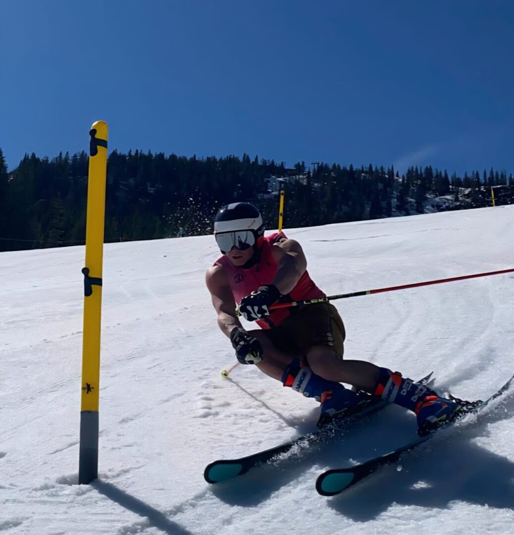 Skier navigating a slalom course on a snowy slope under a clear sky.