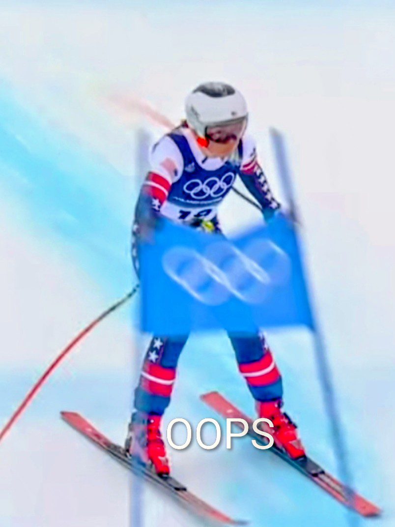 Skier crashes through Olympic gates during a downhill race.