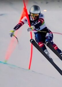 Skier racing down a snowy slope during a slalom event.