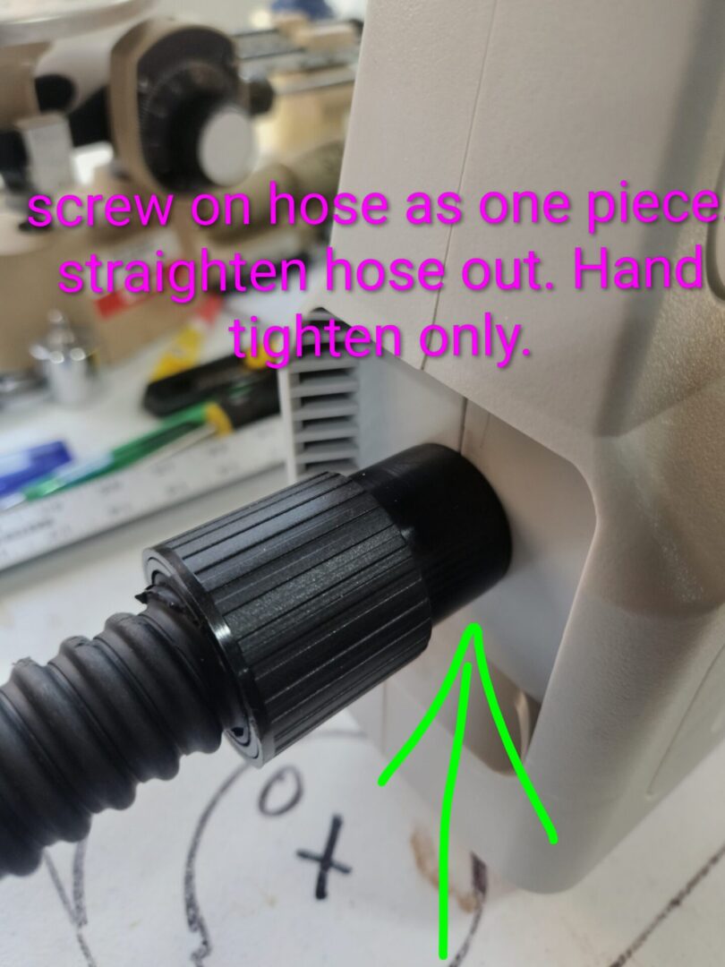 Close-up of a hose connection with a hand tightening it.