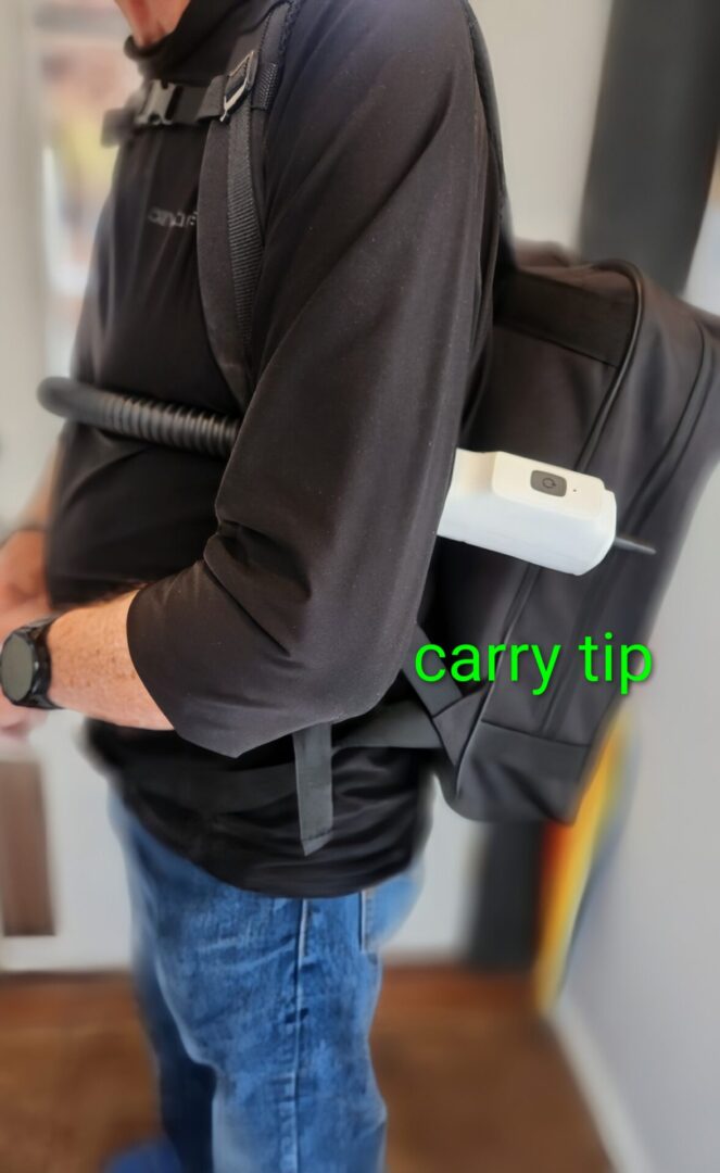 Person wearing a backpack with a visible carry tip label.