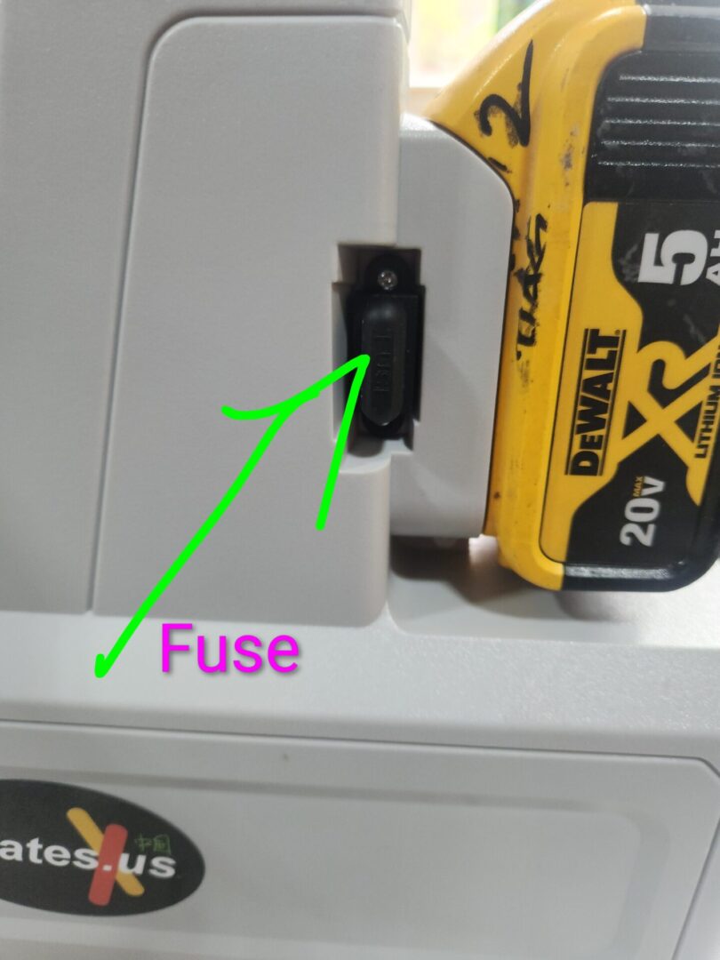 Close-up of a fuse in a device with a green arrow pointing to it.