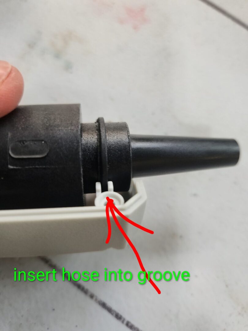 Close-up of a device showing a hose insertion groove.